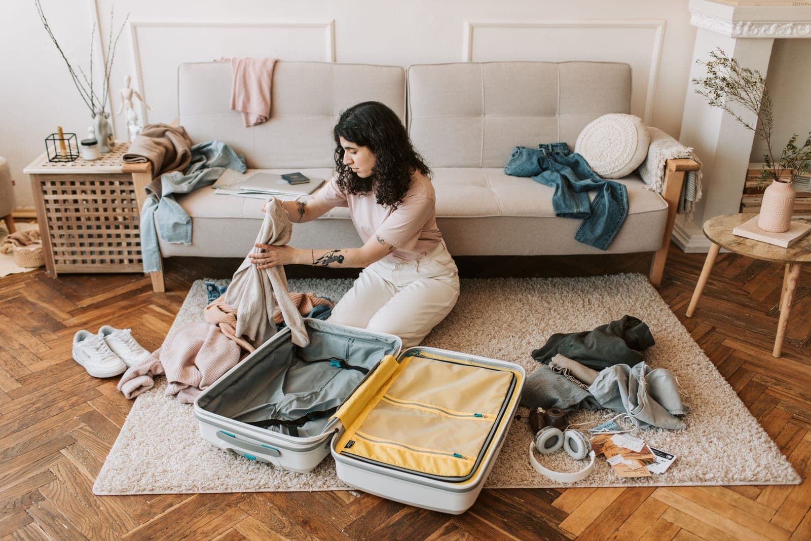 A woman packing a suitcase in her living room